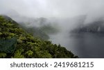 Scenic, misty and foggy landscape view of Lake Billy Mitchell apyroclastic shield volcano deep within dense jungle on the remote tropical island of Bougainville, Papua New Guinea