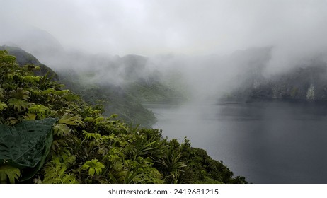 Scenic, misty and foggy landscape view of Lake Billy Mitchell apyroclastic shield volcano deep within dense jungle on the remote tropical island of Bougainville, Papua New Guinea - Powered by Shutterstock