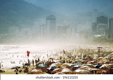 Scenic misty view of a busy day on Ipanema Beach with umbrellas and people crowding the shore in Rio de Janeiro, Brazil