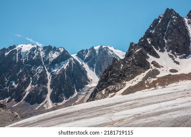 Scenic mountain landscape with glacier under sharp rocks in sunlight. Awesome landscape with glacial tongue and rocky pinnacle in sunshine. Beautiful view to snow mountains at very high altitude. - Shutterstock ID 2181719115