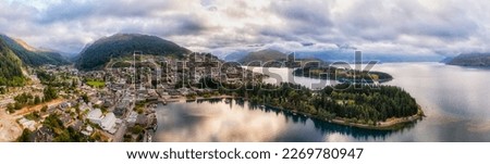 Scenic mountain landscape of QUeenstown city downtown waterfront on lake Wakatipu in New Zealand - aerial panorama.
