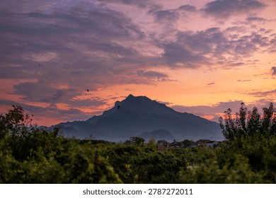 scenic mountain landscape at sunset with dramatic orange sky. silhouetted peaks against a vibrant twilight sky create a peaceful and majestic atmosphere. perfect for nature, travel, and aoutdoor concepts.