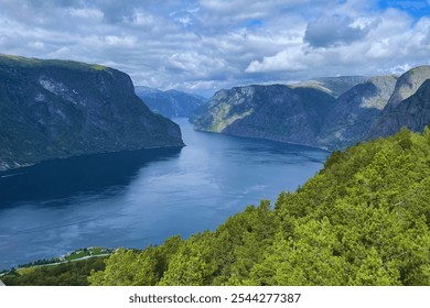 Scenic mountain path leading through rolling hills, with endless views stretching over the valley lake - Powered by Shutterstock