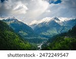 Scenic mountain valley with a winding river and snow-capped peaks in the Parvati Valley, Himachal Pradesh, India.