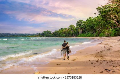 Scenic Neil Island seashore Andaman India at sunset with young tourist couple enjoy a walk along the beach