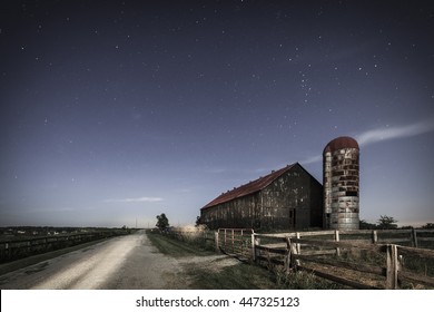 Scenic nighttime image of an old farm barn and a country road in moonlight - Powered by Shutterstock