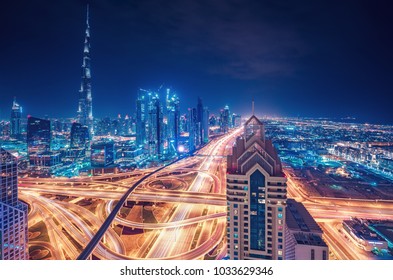 Scenic Nighttime Skyline Of A Big Modern City. Dubai, UAE. Aerial View On Famous Highway Interchange And Skyscrapers.