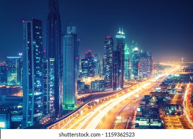 Scenic nighttime skyline of downtown Dubai, United Arab Emirates. Aerial view on highways and skyscrapers in the distance. 