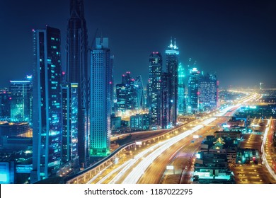 Scenic nighttime skyline of Dubai, United Arab Emirates. Aerial view on highways and skyscrapers in the distance. 