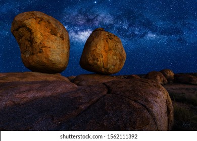 Scenic nocturnal australian outback landscape of Devils Marbles The Eggs by night with milky way, stars field and galaxies. Granite boulders of Karlu Karlu in Northern Territory, Central Australia. - Shutterstock ID 1562111392