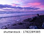 Scenic ocean sunset in Carlsbad California. Colorful sunset at the beach. Soft focus. Waves in the water and purple pink sky.