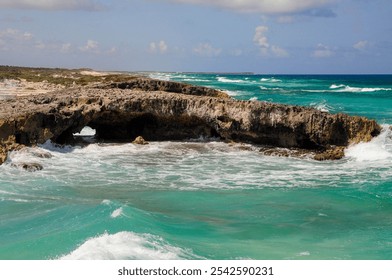 Scenic ocean view of rocky coast and turquoise waves under partly cloudy sky. - Powered by Shutterstock