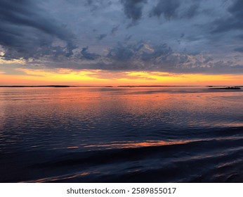 Scenic ocean view at sunset with dramatic clouds and vibrant colors. A serene and tranquil moment in nature, perfect for tourism and relaxation.