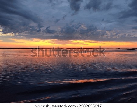Scenic ocean view at sunset with dramatic clouds and vibrant colors. A serene and tranquil moment in nature, perfect for tourism and relaxation.