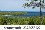 Scenic overlook view of the Green Bay of Lake Michigan in Door County, Wisconsin, with green vegetation, a cove with boats, and the blue water and sky.