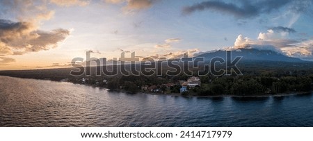 Scenic Panorama Aerial Drone Picture of the coast of Dauin, Dumaguete, Philippines with Mount Talinis in the background during sunset