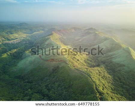 Scenic panorama aerial view on green hills on sunset dusk light