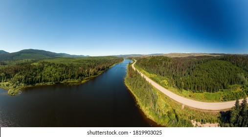 Scenic Panoramic Lake View Of Curvy Road In Canadian Nature On A Sunny Summer Day. North Of Prince George, John-Hart Highway, British Columbia.