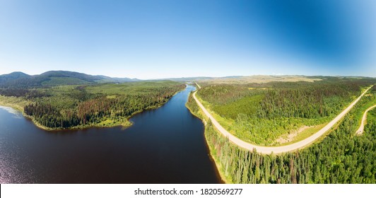 Scenic Panoramic Lake View Of Curvy Road In Canadian Nature On A Sunny Summer Day. North Of Prince George, John-Hart Highway, British Columbia.