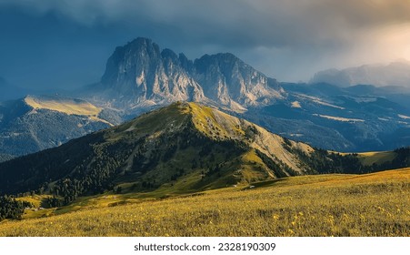 Scenic panoramic view of mountain hills landscape with blooming meadows and majestic alpine mountain peaks in the background on a colorful sunset with overcast sky in summer. amazing nature scenery - Powered by Shutterstock