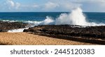 A scenic panoramic view over the cold sea at Ocean Beach, Bunbury, Western Australia in late autumn with white topped foamy waves breaking on shoreline basalt rocks.