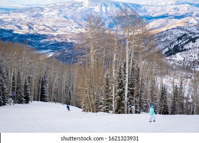 Scenic Panoramic View As Two Skiers Descend The Slopes Of The Aspen Snomass Ski Resort, In The Rocky Mountains Of Colorado.  