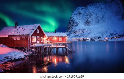 Scenic photo of winter fishing village with northern lights. stunning natural background. Picturesque Scenery of Reinefjord one most popular place of Lofoten islands. Norway. ideal resting place.