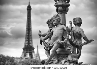 Scenic postcard view in Paris, France with statues of cherubs on a street lamp on the Pont Alexandre III Bridge with the Eiffel Tower standing in black and white monochrome