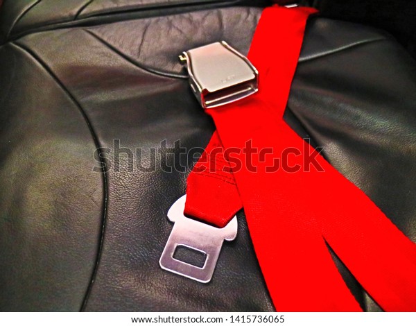 scenic of red seat belt laying over black\
leather in close up and minimal style so impressive equipment\
pattern for awesome transportation\
background