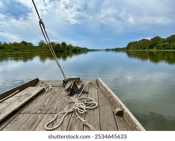 Scenic River Cruise on a Traditional Wooden Boat with Ropes and Calm Views of the Loire’s Natural Shores - Powered by Shutterstock