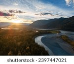 Scenic River in the Valley, surrounded by Mountains. Sunset, Fall Season. Aerial Landscape. Fraser Valley, British Columbia Canada.