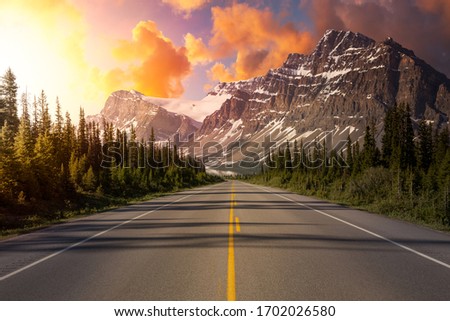 Scenic road in the Canadian Rockies during a vibrant sunny summer sunrise. Sky Composite. Taken in Icefields Parkway, Banff National Park, Alberta, Canada.