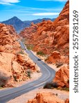 Scenic road in the famous “Valley of Fire“ State Park, a public recreation and nature preservation area south of Overton, Nevada (USA) in Mojave Desert, near Las Vegas. Red sandstone frames the street