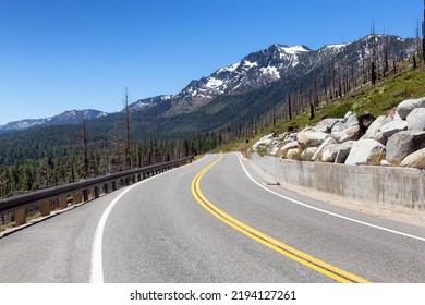 Scenic Road Surrounded By Trees And Mountains On A Sunny Day. Summer Season. Lake Tahoe, California, United States. Adventure Travel.