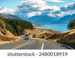 Scenic road trip of Mt Cook or Aoraki over winding road with motorhome driving and Lake Pukaki on sunny day at Peters lookout, New Zealand