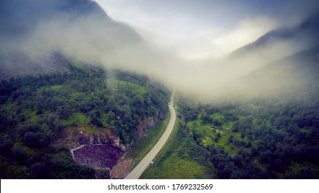 Scenic Road, View From Above. Empty Road. Rocky Road Goes Into The Distance Into The Blue Sky. Mountain Road In The Summer. Mountain Pass In Norway. Top View Through The Fog