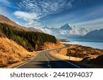 Scenic road winding its way along the shores of the alpine Lake Pukaki with Mt Cook in the background