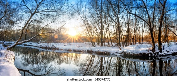 Scenic russian winter wonderland sunset view of non frozen river with trees scenery reflections on water panoramic wide nature background scene