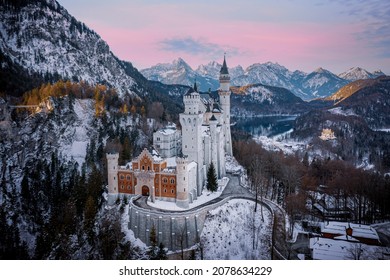 A scenic shot of the Neuschwanstein Castle in Germany surrounded by snowy mountain forests - Powered by Shutterstock