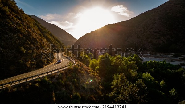 A scenic shot of a road\
and mountain silhouettes at Azusa Canyon in Canyon, California\
during sunset