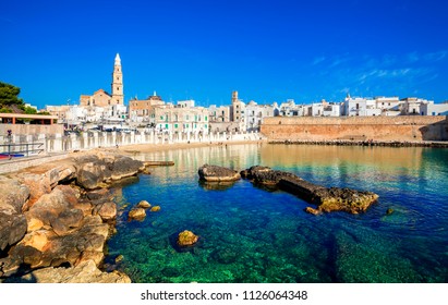 Scenic sight in Monopoli, province of Bari, region of Apulia, southern Italy. City scape harbor walled city Cathedral.