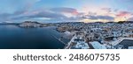 Scenic snowy evening at a bustling harbor with dock and buildings