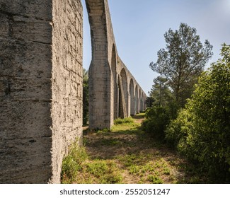 Scenic summer landscape view of ancient stone aqueduct, famous historic landmark of Castries, Herault, France - Powered by Shutterstock