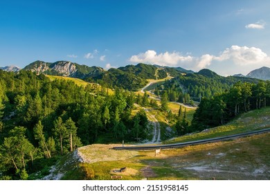 Scenic summer view of Vogel ski resort area near famous Bohinj lake, Triglav national park, Julian Alps, Slovenia. Sports attractions, white roads, green trees and mountains illuminated with sunlight
