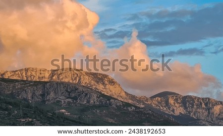 Scenic sunset view of cloud covered Biokovo mountains in majestic Dinaric Alps seen from Makarska, Split-Dalmatia, Croatia, Europe. Coastline of Makarska Riviera. Hiking in the Balkans. Wanderlust