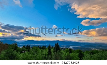 Scenic sunset view of Lake Faak seen from Altfinkenstein at Baumgartnerhoehe, Carinthia, Austria. Tranquil atmosphere on hiking trail in spring. Overlooking Villach area surrounded by Austrian Alps