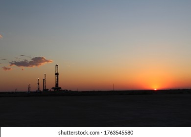 Scenic Sunset view of West Texas landscape with FIVE drilling rigs in the background