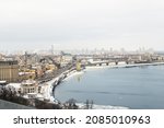 Scenic top panoramic view of Kyiv city Podol old center over ice covered Dnepr river Rybalskiy island panoramic landscape white winter snowfall. Cold season Ukrainian capital Kiev blizzard panorama