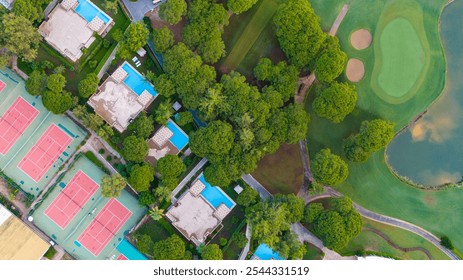 Scenic top-down view of a resort complex featuring villas, swimming pools, and tennis courts amid a tranquil natural setting. - Powered by Shutterstock