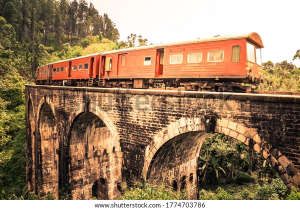 Scenic Train Ride\
over the world renowned demodara nine arches bridge. Train going\
towards the ella tunnel in the morning light through beautiful lush\
green and tea estates